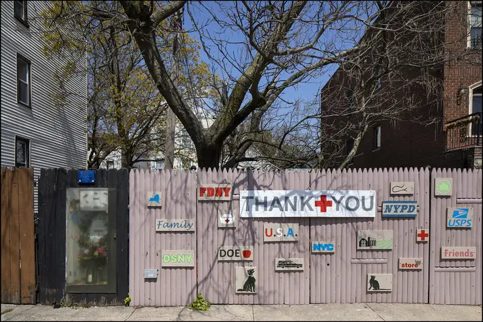 A photo of a wood fence covered in thank you signs in Red Hook